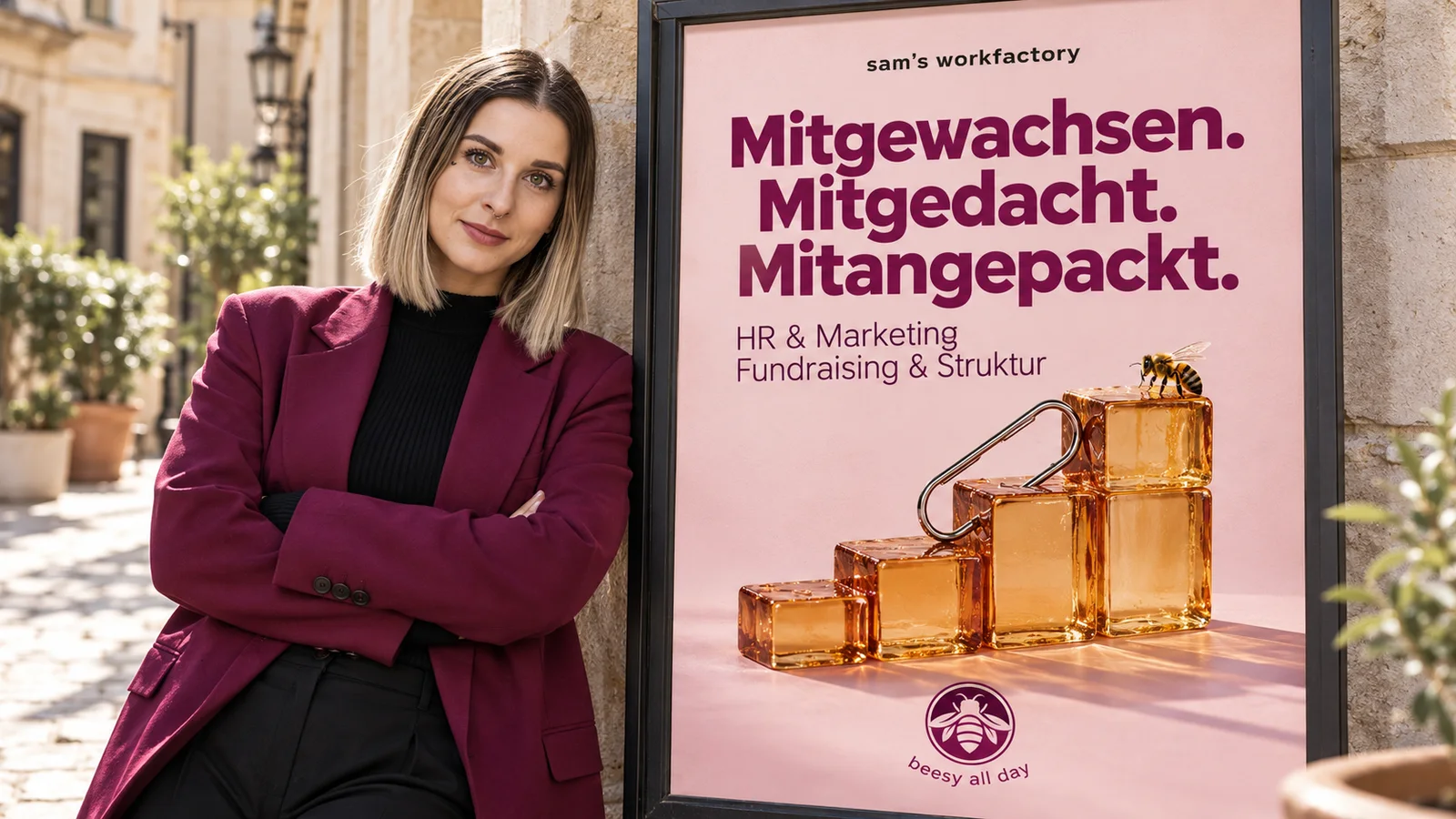 Sam Fischer lehnt neben einem Plakat von sam's workfactory: Mitgewachsen. Mitgedacht. Mitangepackt.